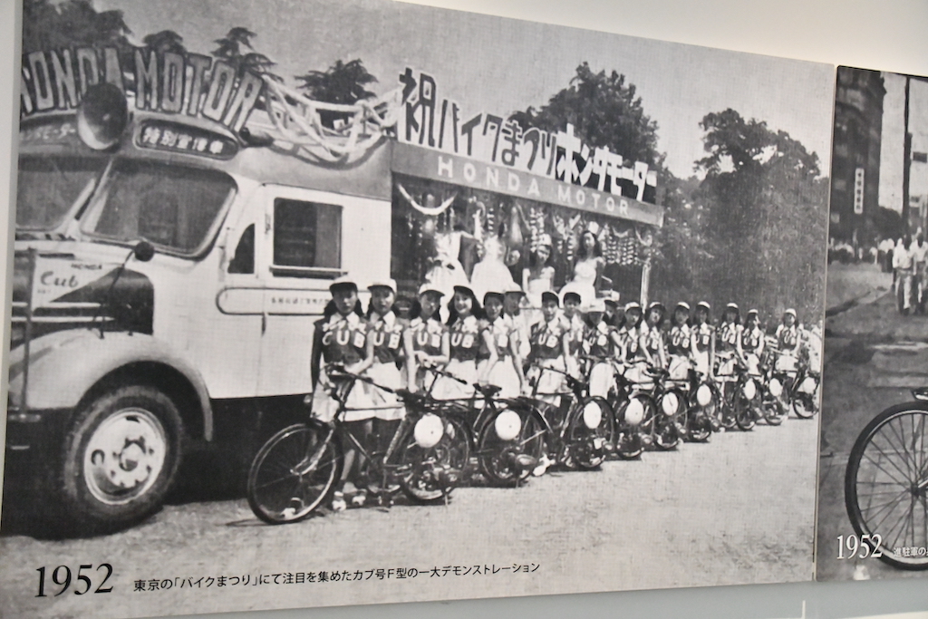 1952年8月に開催された『モーターバイク祭』でも注目を集めたカブF型の一大デモンストレーション。同月発行のホンダ月報No.12には、「当日は他メーカーも含めて150余りの宣伝車が、日比谷公園から日本橋、上野、池袋、新宿、渋谷、芝の都内目抜き通りをデモ行進し、モーターバイクの一大普及運動を展開した」と記されている。