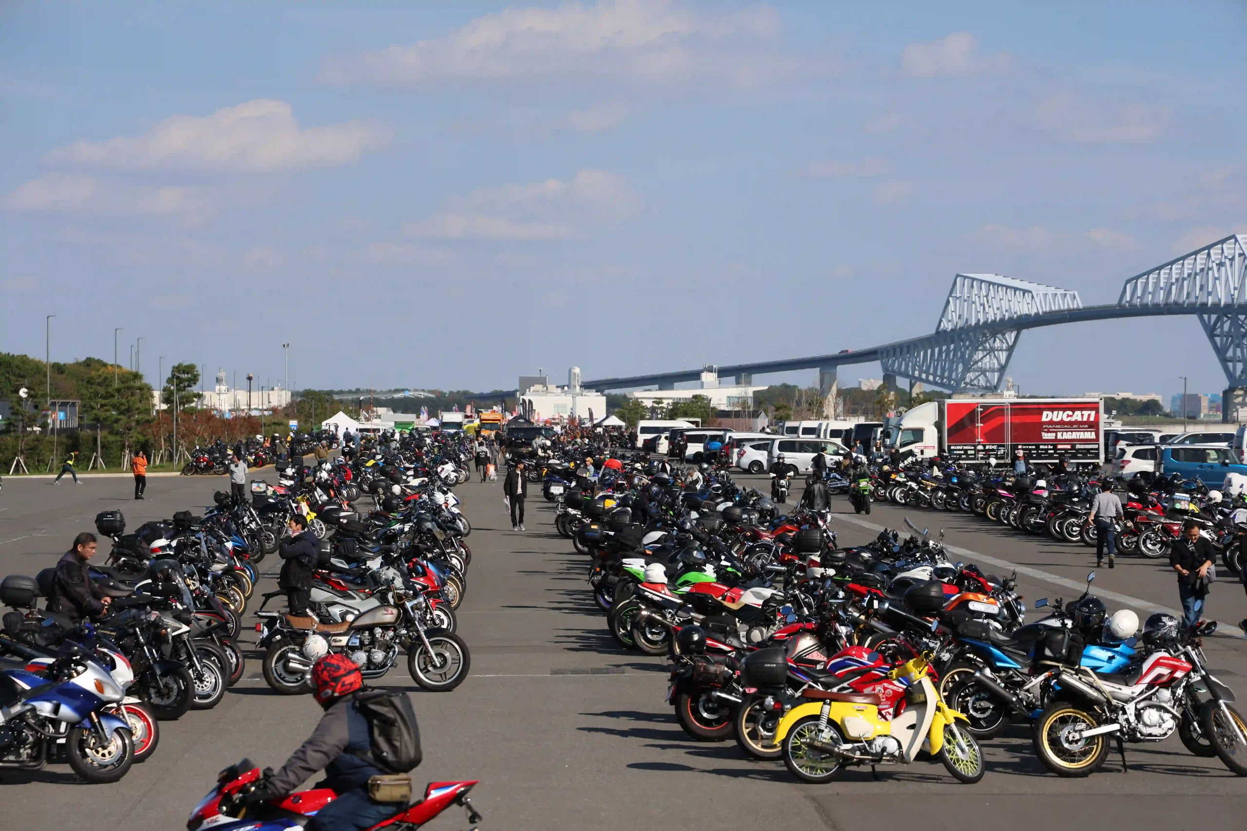 「ウェビックフェスティバル 2025 in お台場」の二輪駐輪場。一番奥がメインのイベント会場で右は東京ゲートブリッジ。