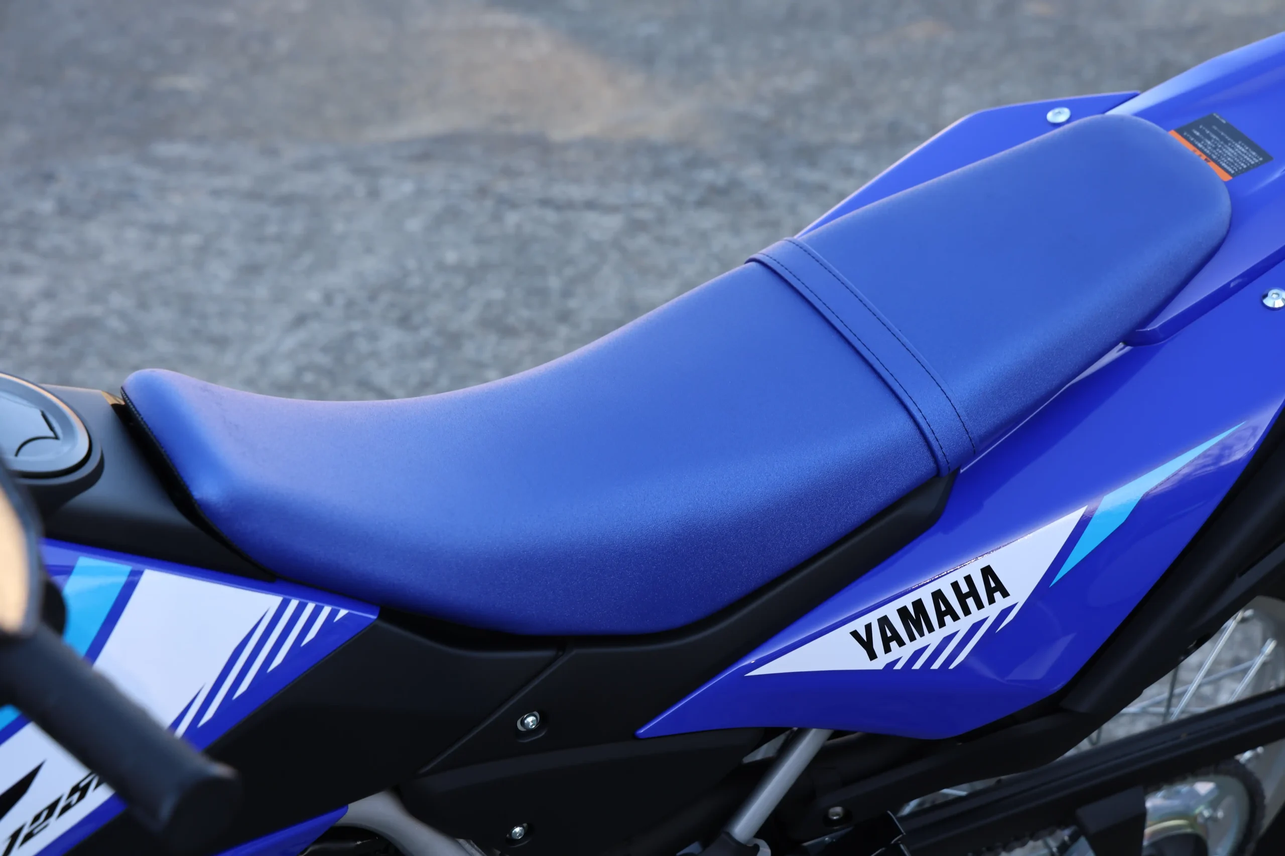 前後一体型のシートを採用。しっかり知り込まれた鞍部とサイドカバーへと伸びる前後のラインもスリムで、スタンディングにせよシッティングにせよ重移動がしやすい。