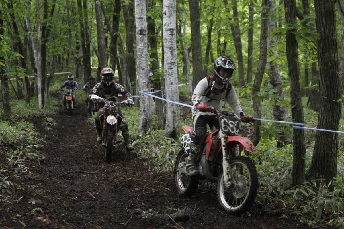 エンデューロはその名の通り“耐久（Endurance）”が語源で、ウッズやロックセクションなどの難所を織り交ぜたコースを長時間走り続ける長丁場の競技。60分、90分はもとより3時間や8時間といった長丁場のレースも当たり前。中には2日や6日間といった長期の競技時間でタイヤ交換などの整備力の高さが求められる競技もある。