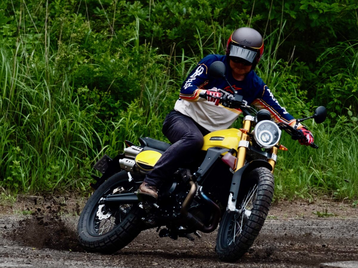 国内外、様々なメーカーから『スクランブラー』モデルが登場しているが、“オフロード走行を想定した『スクランブラー』”の代表はファンティックのCABALLERO　Scramblerシリーズ。そのキャラクターはやはりテールハッピーで、後輪をズリズリとパワースライドするのが楽しいモデルになっている。写真はCABALLERO　Scrambler 500（2023年モデル）に乗る筆者　谷田貝　洋暁。