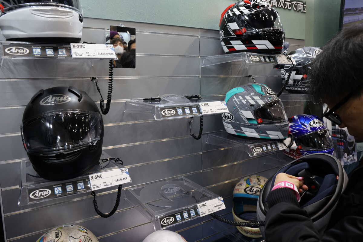 アライヘルメット『X-SNC』の販売は7月～8予定で、従来通りソリッドモデル（グラスホワイト、艶消しグレー、ブラック、艶消しブラック）がまず登場し、その後グラフィックモデル（PILOT/KATAKANA）が発売される。