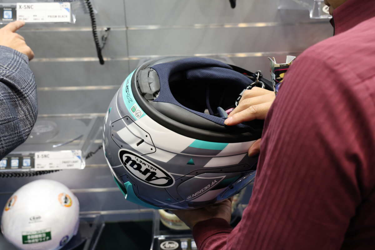 アライヘルメット『X-SNC』の軽さを実際に手に取って確かめる来場者。