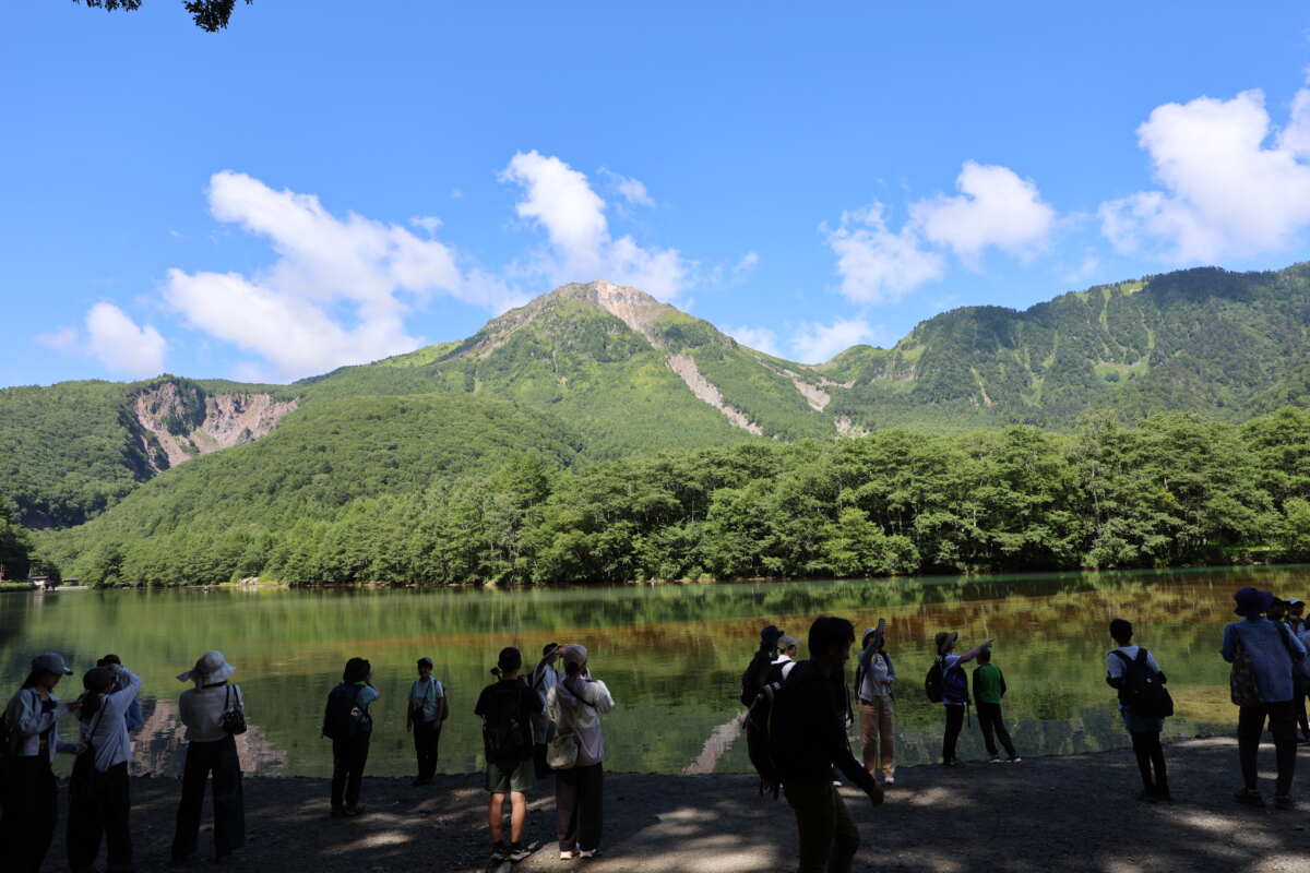 上高地の代表的な景勝地である大正池。その名のとおり大正時代に、正面の焼岳（やけだけ）が崩れた土砂で梓川が堰き止められてできた。今回の登山はこの焼岳（2455m）を目指す。